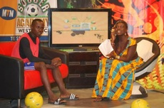 Akua interviews a contestant, live on set